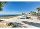 Scenic view of a sandy beach with picnic shelters, tables, and picturesque ocean views at 4256 Rudder Way, New Port Richey, FL 34652