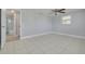 This bedroom has neutral walls, light-colored floors and a ceiling fan at 4256 Rudder Way, New Port Richey, FL 34652