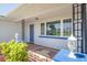 Charming front porch with decorative lamps, a tiled floor, and a blue front door at 4256 Rudder Way, New Port Richey, FL 34652