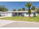 Charming single-story home with a well-manicured lawn and a mature palm tree in the front yard at 4256 Rudder Way, New Port Richey, FL 34652