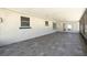 Screened-in patio featuring tile flooring, a textured white exterior wall and access to an outdoor patio and lush backyard at 4256 Rudder Way, New Port Richey, FL 34652