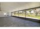 The screened-in patio features tile flooring, offering tranquil views of the yard with mature palm trees and greenery at 4256 Rudder Way, New Port Richey, FL 34652