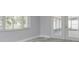 Sunroom featuring wood-look tile, view of trees, and white framed glass doors at 4256 Rudder Way, New Port Richey, FL 34652