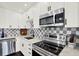 Modern kitchen features stainless steel appliances, white cabinets, and checkered backsplash and luxury countertop at 5007 Starfish Se Dr # A, St Petersburg, FL 33705