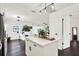 Bright white kitchen island with pendant lighting open to living space featuring hardwood floors and modern design at 5007 Starfish Se Dr # A, St Petersburg, FL 33705