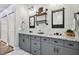Bathroom boasting double sinks, granite countertops, industrial shelving, and modern lighting at 5416 Twin Creeks Dr, Valrico, FL 33596