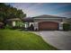 Charming single-Gathering home with lush landscaping, a well-manicured lawn, and a welcoming entryway at 5416 Twin Creeks Dr, Valrico, FL 33596