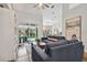 Bright living room featuring a comfortable blue sofa, modern decor, and sliding glass doors to the backyard at 5416 Twin Creeks Dr, Valrico, FL 33596