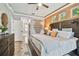 Bright main bedroom with rustic wood accents, modern lighting, and a view into the bathroom at 5416 Twin Creeks Dr, Valrico, FL 33596