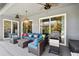 Cozy covered patio with ample seating, a grill, and views of the landscaped backyard at 5416 Twin Creeks Dr, Valrico, FL 33596