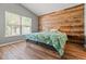 Bedroom with a wooden headboard feature wall, neutral walls, and hardwood floors at 5902 War Admiral Dr, Wesley Chapel, FL 33544
