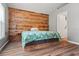 Bedroom with a wooden headboard feature wall, neutral walls, and hardwood floors at 5902 War Admiral Dr, Wesley Chapel, FL 33544