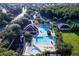 Aerial view of a community pool, playground, and clubhouse surrounded by trees at 5902 War Admiral Dr, Wesley Chapel, FL 33544