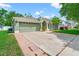 Inviting single-story home featuring a lush lawn and attached two-car garage at 5902 War Admiral Dr, Wesley Chapel, FL 33544