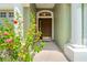 Close-up of front door with decorative columns and vibrant flowers, creating an inviting entrance at 5902 War Admiral Dr, Wesley Chapel, FL 33544
