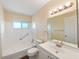 Well-lit bathroom features a shower/tub, toilet, vanity, and mirror, along with a wall-mounted light fixture at 703 Bel Air Ave, Sun City Center, FL 33573