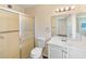 Bathroom showcases a walk-in shower, toilet, vanity, and a well-lit mirror, offering a clean and bright space at 703 Bel Air Ave, Sun City Center, FL 33573