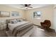 Comfortable bedroom features a ceiling fan, a bedside table with a lamp, and a window with neighborhood views at 703 Bel Air Ave, Sun City Center, FL 33573