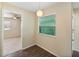 The hallway area leads to a living room with a dining area and features a window offering natural light at 703 Bel Air Ave, Sun City Center, FL 33573