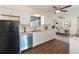 Modern kitchen with white cabinets, stainless steel appliances, and dark wood floors at 703 Bel Air Ave, Sun City Center, FL 33573