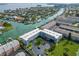 An aerial view of a waterfront condo complex with docks, boat parking, and verdant green spaces at 719 Pinellas Bayway S # 309, Tierra Verde, FL 33715