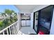 Balcony featuring a laundry closet, palm trees, and sliding glass door access at 719 Pinellas Bayway S # 309, Tierra Verde, FL 33715