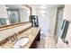Bright bathroom featuring granite countertops, a large mirror, and walk-in shower at 719 Pinellas Bayway S # 309, Tierra Verde, FL 33715