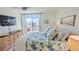 Well-lit bedroom features a ceiling fan, a flat screen, and a sliding glass door to the balcony at 719 Pinellas Bayway S # 309, Tierra Verde, FL 33715