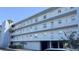 Low angle view of the condo building featuring multiple stories with balconies and ground-level parking at 719 Pinellas Bayway S # 309, Tierra Verde, FL 33715