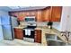 Kitchen featuring granite counters, wooden cabinets, stainless steel appliances, and tile backsplash at 719 Pinellas Bayway S # 309, Tierra Verde, FL 33715