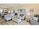 Cozy living room with a large sectional sofa, glass coffee table, and coastal decor at 719 Pinellas Bayway S # 309, St Petersburg, FL 33715