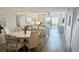 Bright open-concept living and dining area with wood floors and sliding glass doors to the balcony at 719 Pinellas Bayway S # 309, Tierra Verde, FL 33715