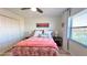 Cozy bedroom with a floral-patterned bedspread, bedside tables, and a large window at 719 Pinellas Bayway S # 309, Tierra Verde, FL 33715