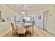 The dining room has a round table, upholstered chairs, and a modern chandelier at 719 Pinellas Bayway S # 309, Tierra Verde, FL 33715