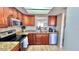 Updated kitchen with wood cabinetry, granite counters and stainless appliances overlooks dining area at 719 Pinellas Bayway S # 309, Tierra Verde, FL 33715