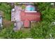 Aerial view of a home with a red roof, pool, and mature trees at 7609 Barry Rd, Tampa, FL 33615