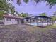 Expansive backyard with a screened-in pool, offering ample space for outdoor activities at 7609 Barry Rd, Tampa, FL 33615