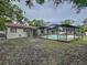 Expansive backyard with a screened-in pool, offering ample space for outdoor activities at 7609 Barry Rd, Tampa, FL 33615