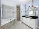 Bathroom featuring sleek tile floors, a double vanity, and a separate shower at 7609 Barry Rd, Tampa, FL 33615