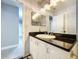 Updated bathroom with white vanity, black countertop, and ample storage at 7609 Barry Rd, Tampa, FL 33615