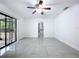 Light and airy bedroom features tile flooring, a ceiling fan, and access to a patio at 7609 Barry Rd, Tampa, FL 33615