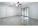 A neutral tone bedroom with tile flooring and sliding glass doors leading to an outdoor pool at 7609 Barry Rd, Tampa, FL 33615
