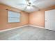 Bedroom features a ceiling fan, window, ceramic floors, and neutral colored walls at 7609 Barry Rd, Tampa, FL 33615