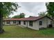 View of home exterior showing lawn and gardens at 7609 Barry Rd, Tampa, FL 33615
