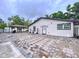 Rear view of home featuring brick-paved patio with pergola, ideal for outdoor enjoyment at 7609 Barry Rd, Tampa, FL 33615