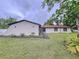 View of home exterior showing lawn and gardens at 7609 Barry Rd, Tampa, FL 33615