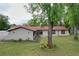 Exterior of a charming home with a well-manicured lawn and mature trees in a tranquil neighborhood at 7609 Barry Rd, Tampa, FL 33615