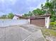 Home featuring a two-car garage, a white fence, and a concrete driveway at 7609 Barry Rd, Tampa, FL 33615