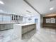 Spacious kitchen with a large central island, sleek gray cabinets, and modern lighting fixtures at 7609 Barry Rd, Tampa, FL 33615