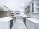 Modern kitchen boasts a large island with bar seating, stainless steel appliances, and gray cabinetry at 7609 Barry Rd, Tampa, FL 33615